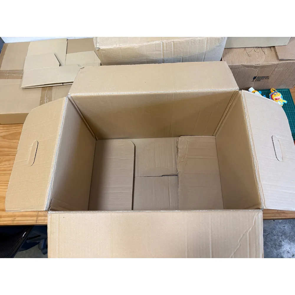 Looking down into the open APT box: plain, clean double-wall board inside with the four flaps folded out