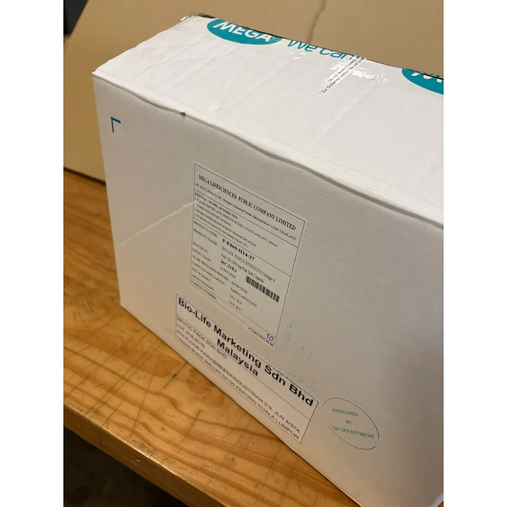 The MG box closed on the bench: white-coated double-wall carton with the Mega print and shipping labels of its first use